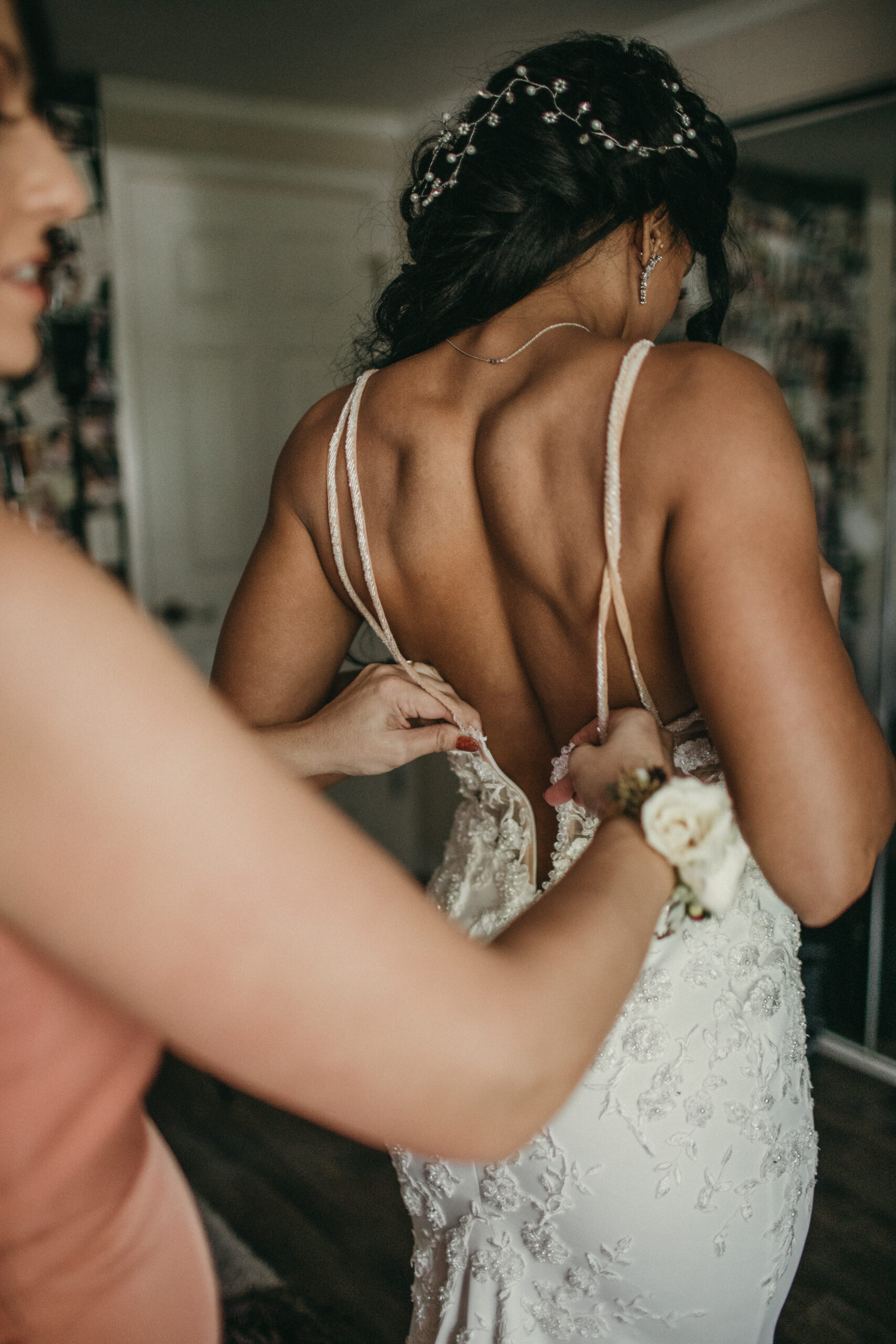 Bride preparing for her wedding day, wearing a lace gown and floral accessories.