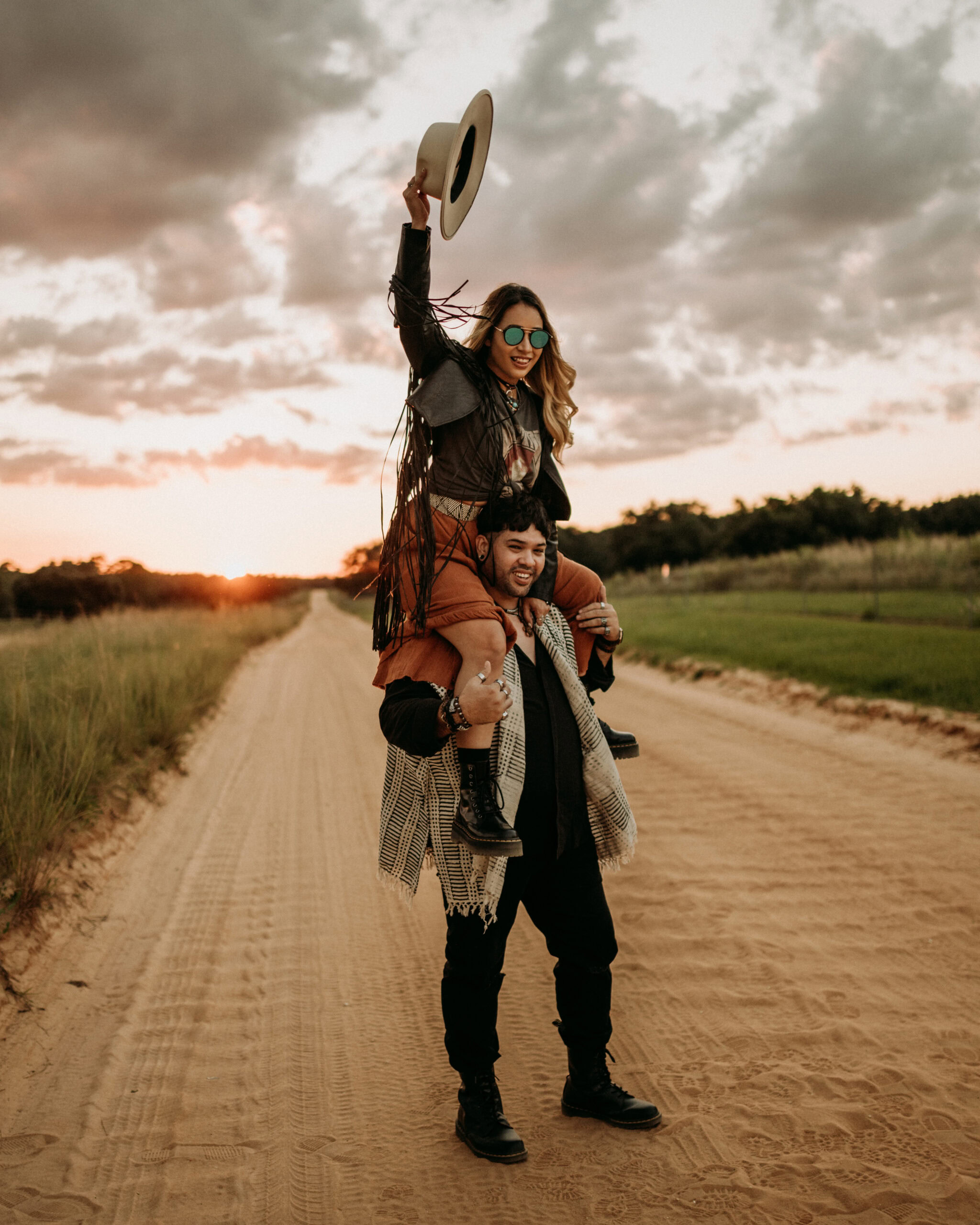 Angie and Marko enjoying outdoor adventure on a dirt road at sunset.
